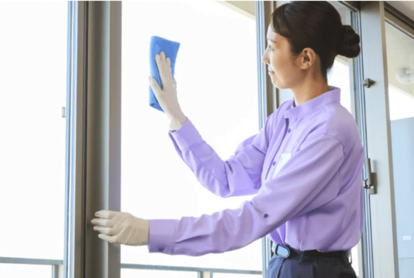 窓の清掃をしている女性スタッフの写真